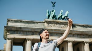 Tourist macht vor dem Brandenburger Tor ein Selfie.