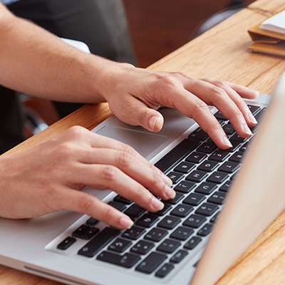 Schmuckbild Laptop mit Händen auf der Tastatur